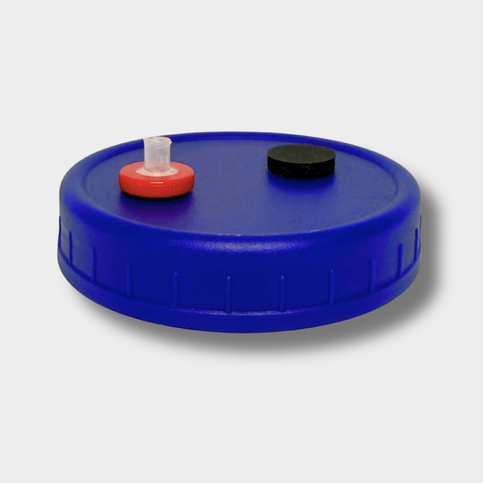 A completely assembled liquid culture jar lid for mushroom growing, featuring a micron filter and self healing injection port